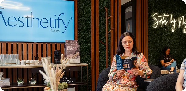 Patient reading in an aesthetic clinic waiting area.