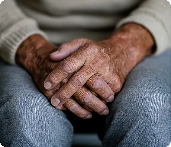 Close-up of elderly hands resting together.