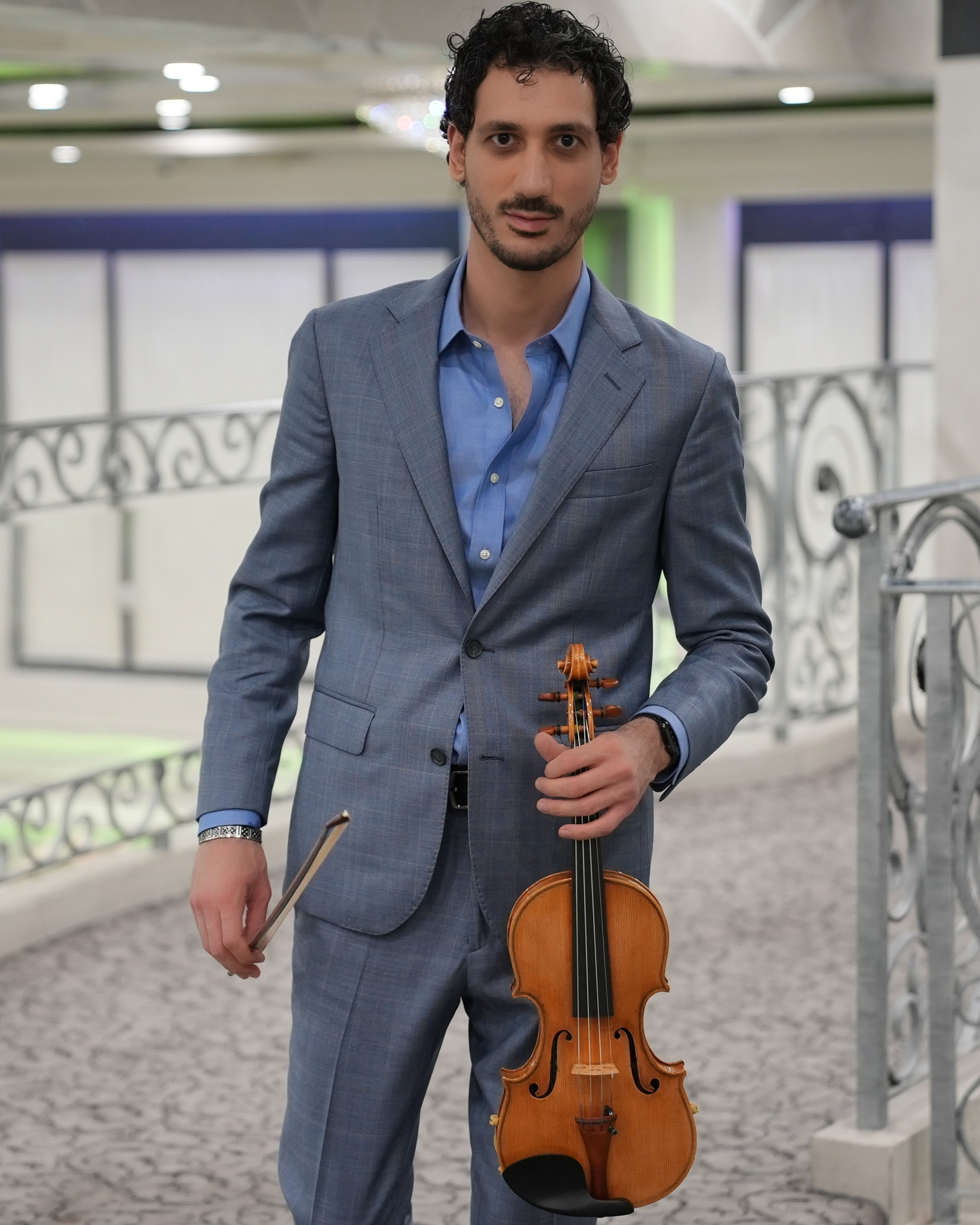 Nick Kelian holding a violin in a luxury restaurant