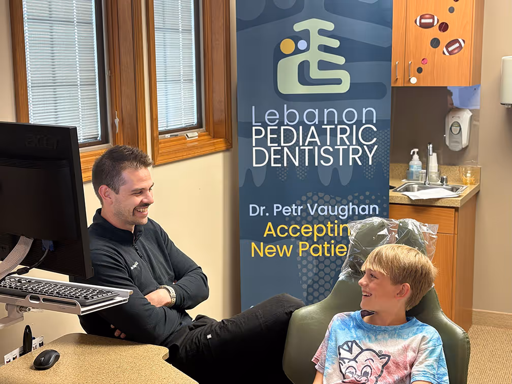 Dr. Vaughan laughing with 10-year-old boy in dental chair, building trust at Lebanon kids dental practice