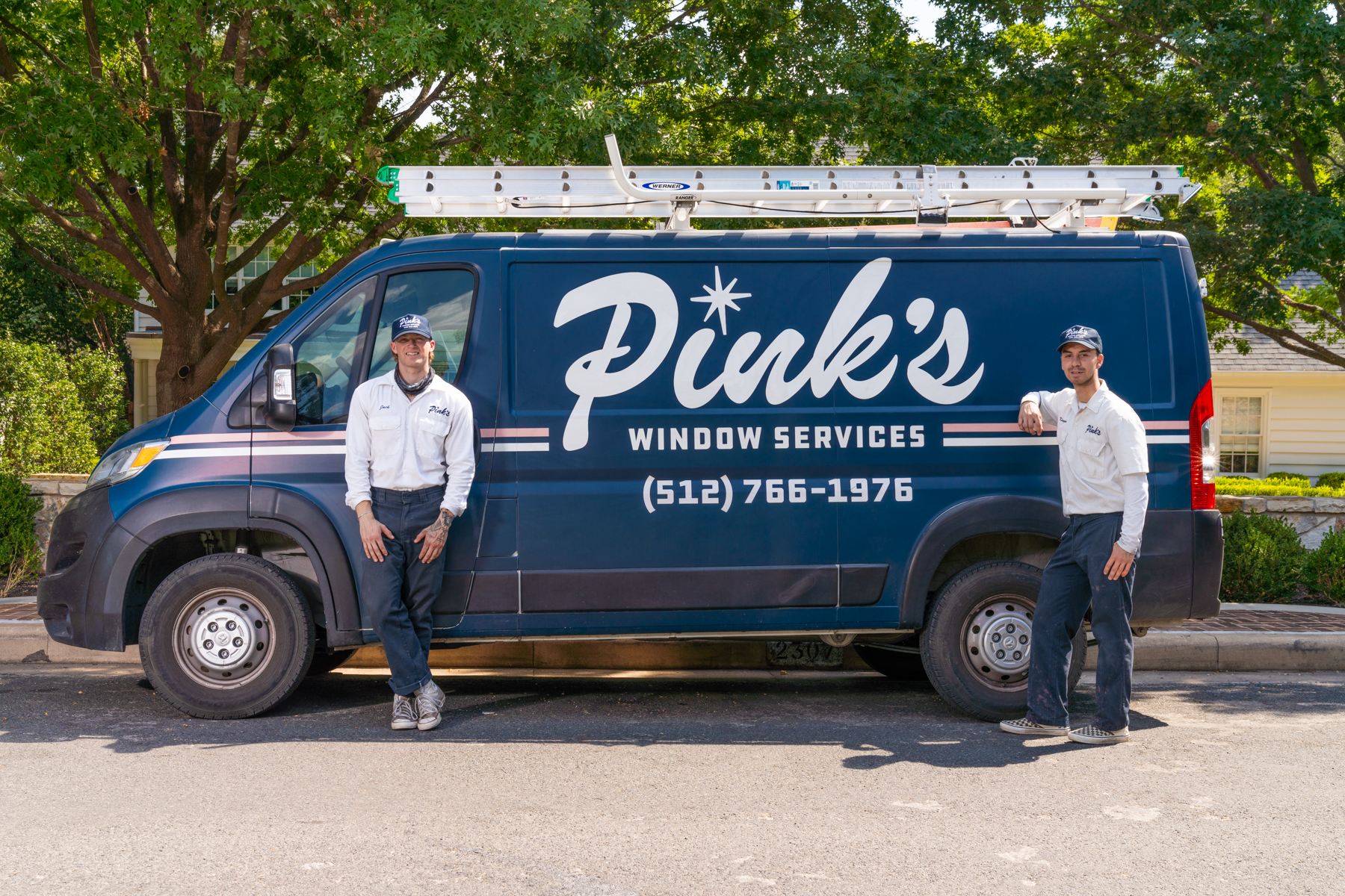 Two business owners standing beside their branded service van