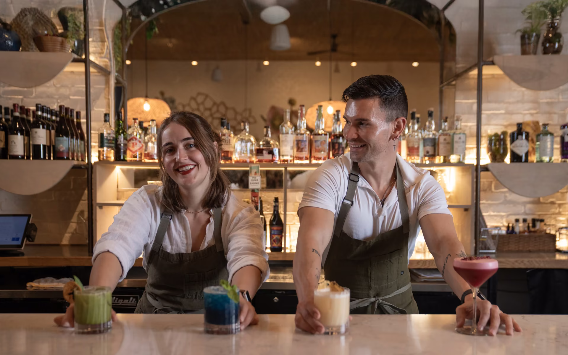 Bartenders preparing cocktails behind a bar