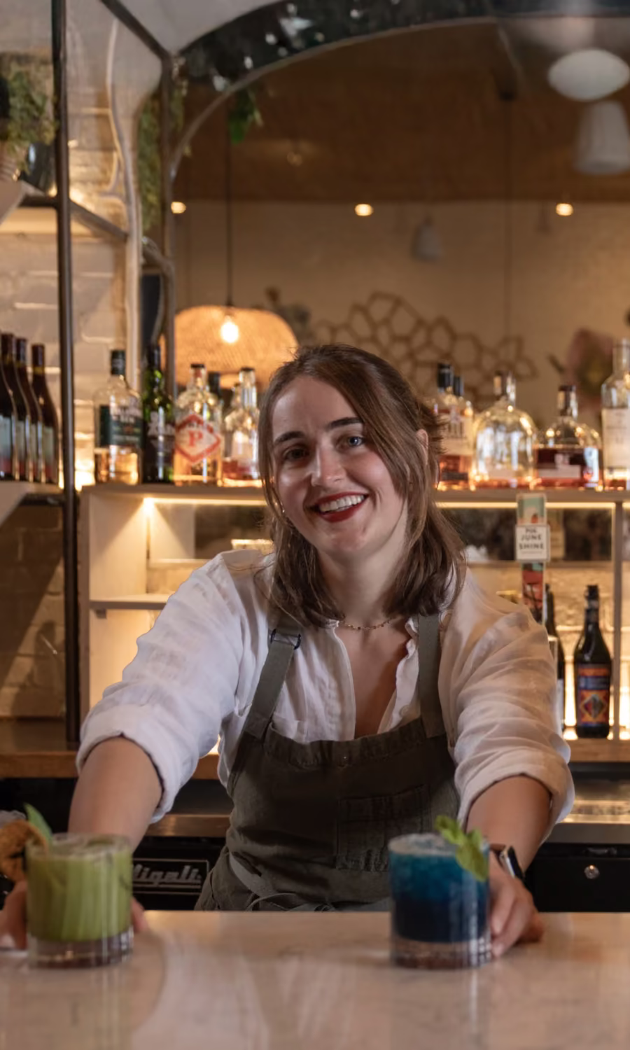 Bartenders preparing cocktails behind a bar