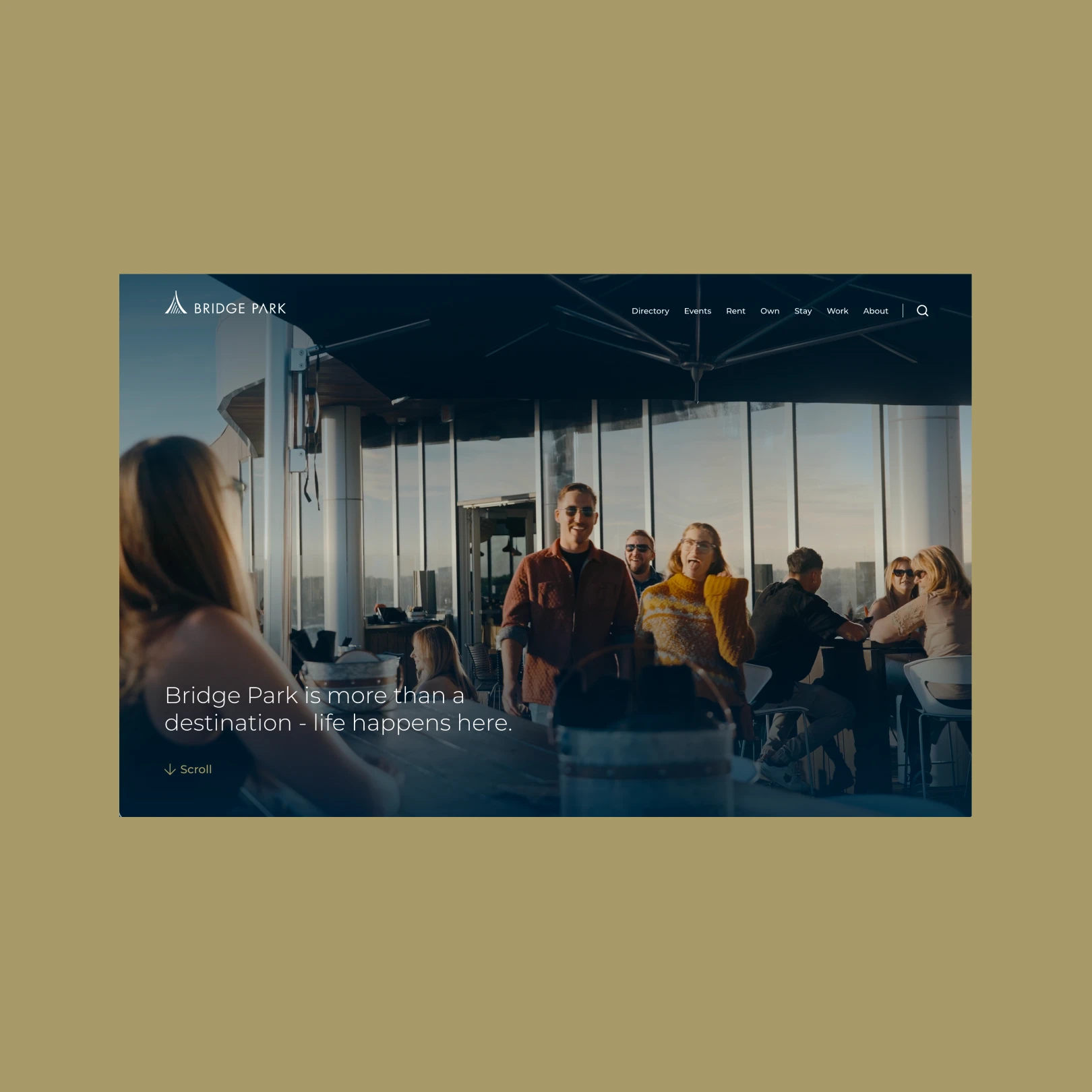 Bridge Park website showing group of people socializing at an outdoor rooftop seating area with glass windows and umbrellas.