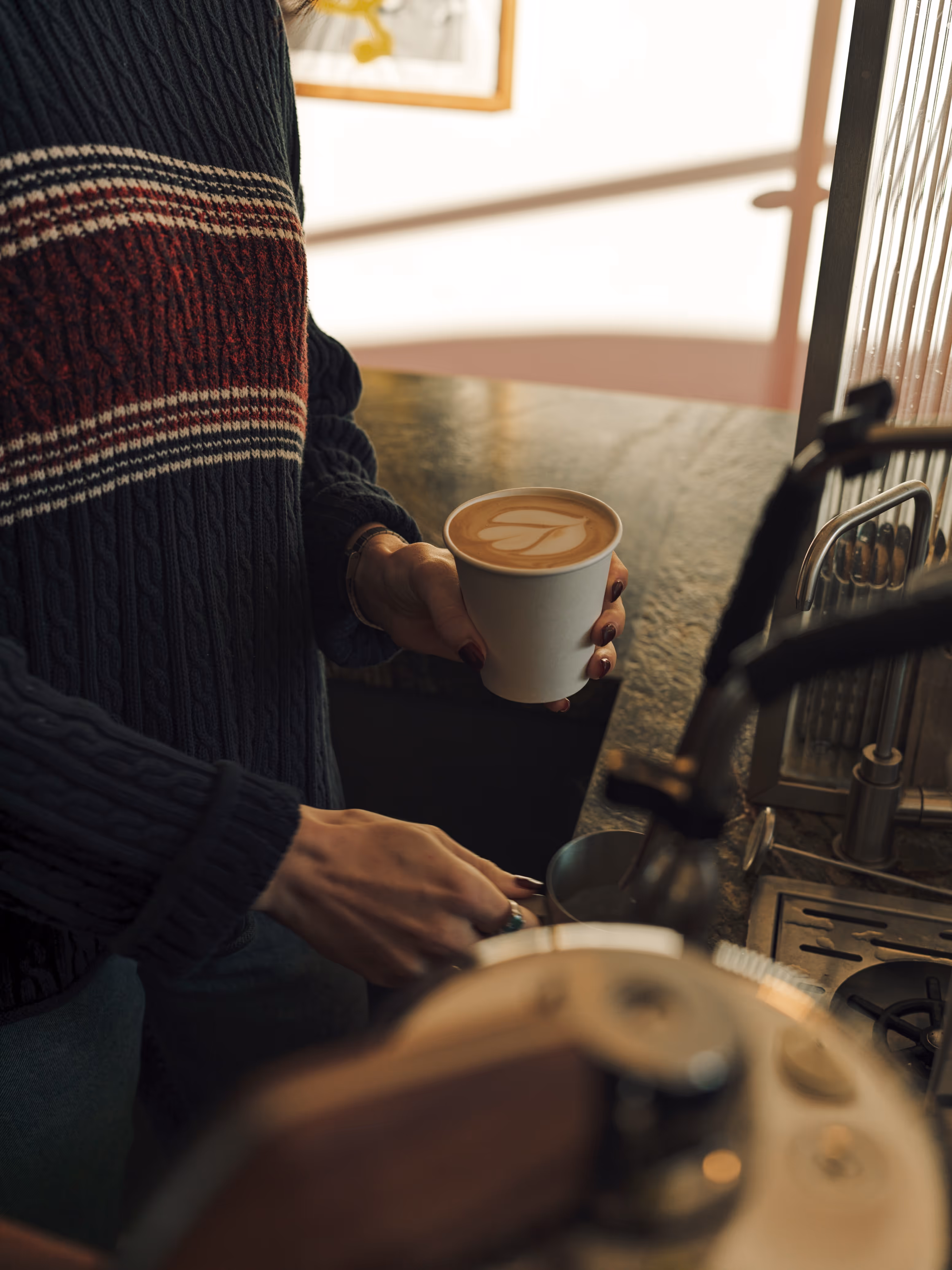 A barista pouring a coffee into a cup