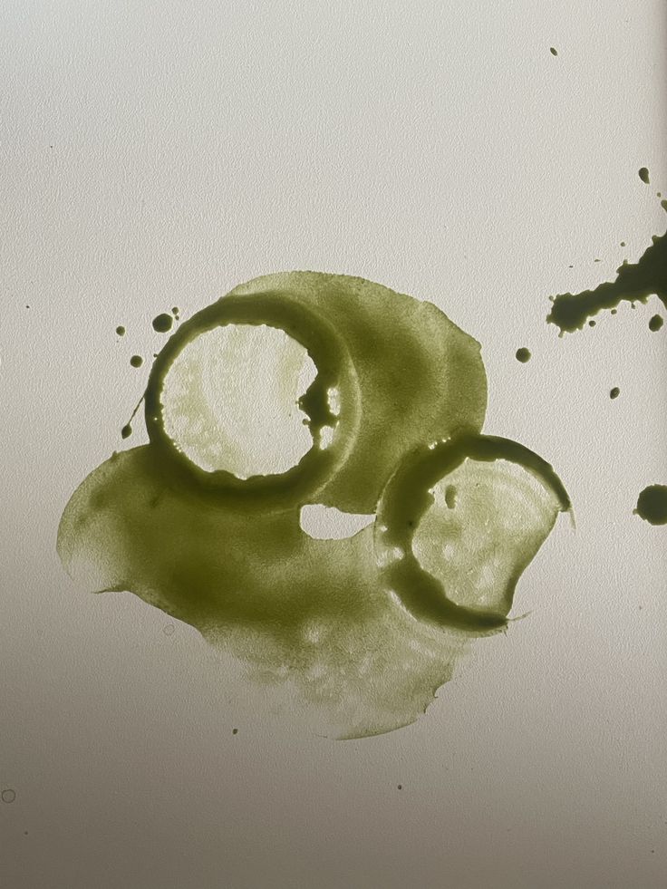 Abstract green ink wash resembling matcha rings on paper