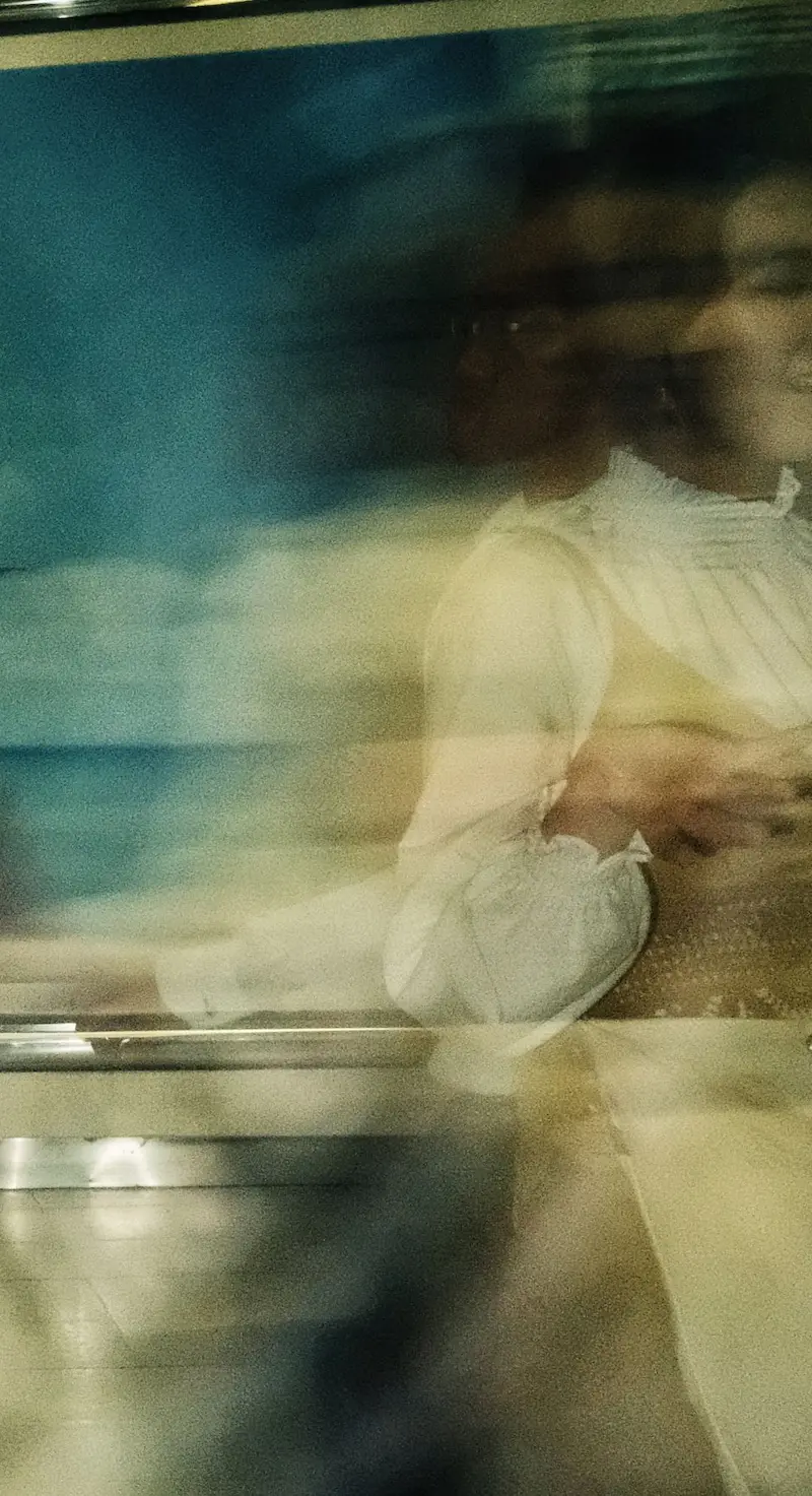 Blurred double-exposure portrait of a woman in a white blouse