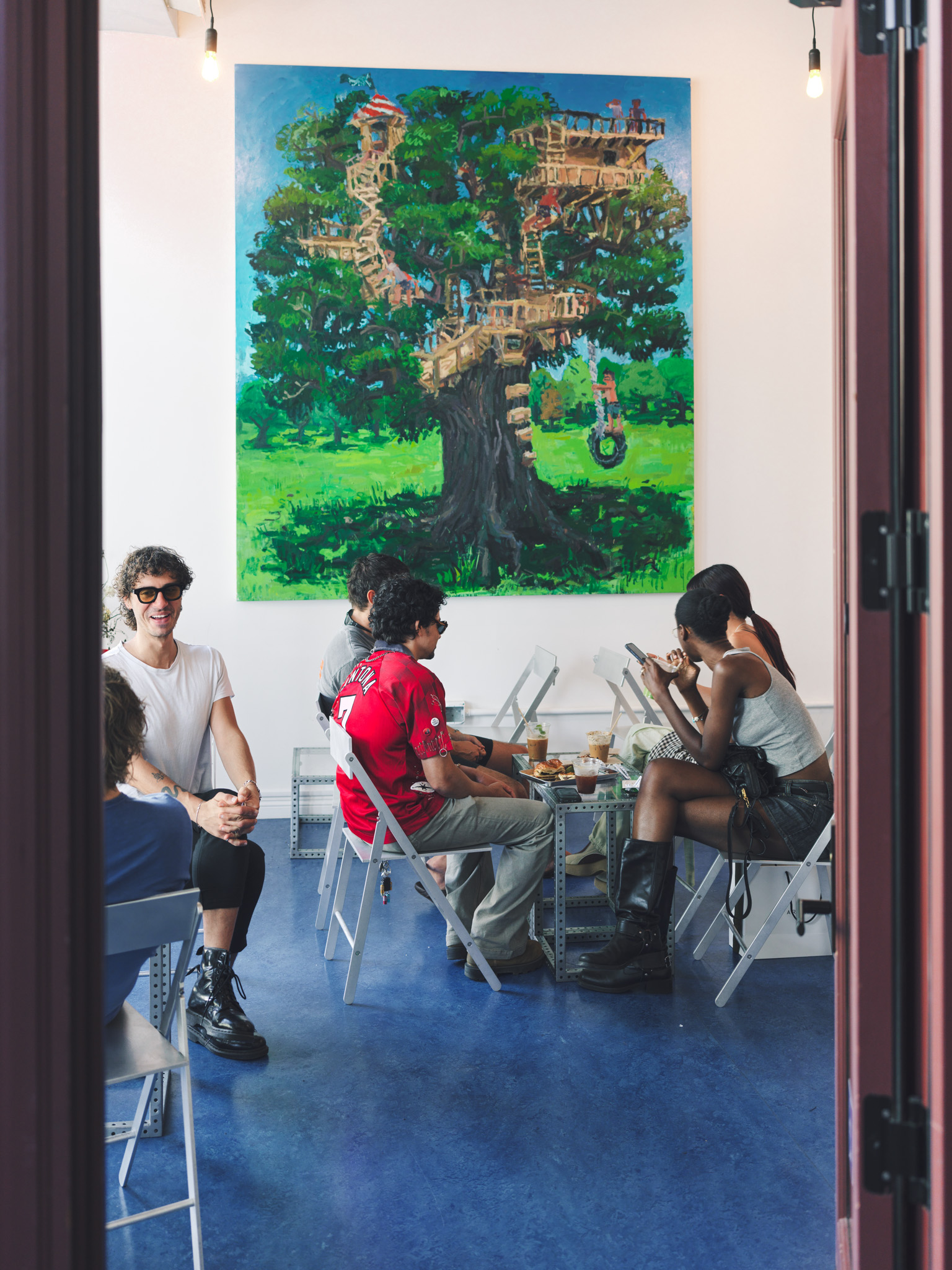 Customers seated beneath a treehouse mural inside Jurassic Magic's MacArthur Park shop