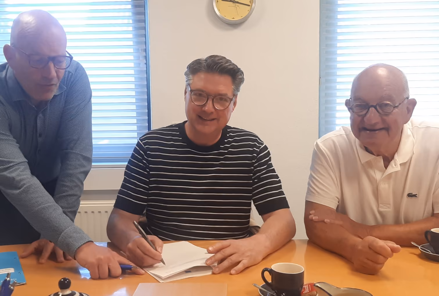 Secretaris Erwin Bomans zet zijn handtekening onder de nieuwe statuten.