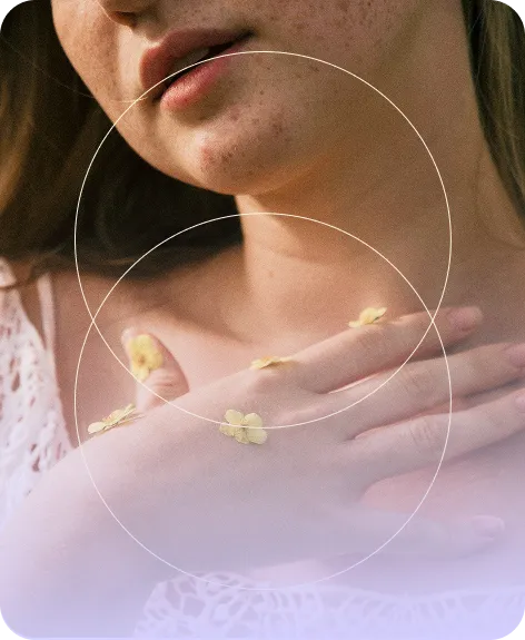 Close-up of a woman with her hand on her chest, small yellow flowers placed on her fingers and hand.