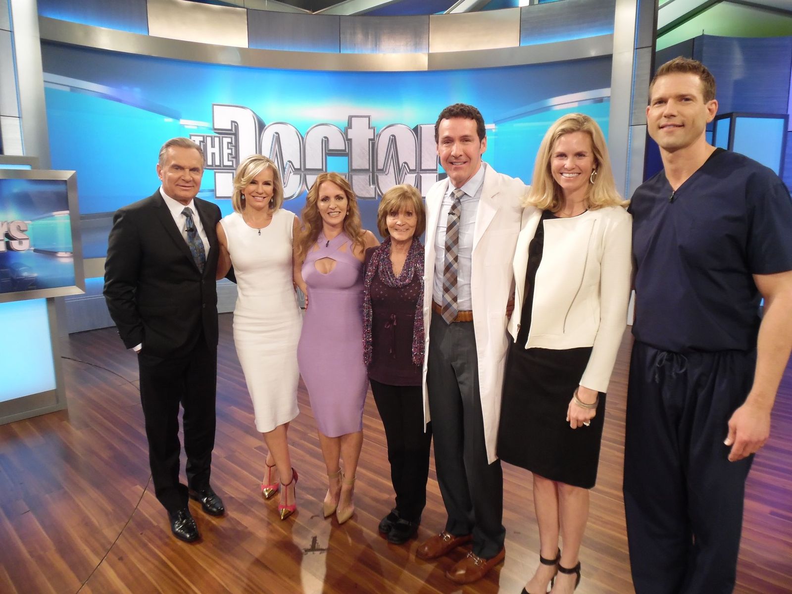 A group of people standing on the set of a TV show