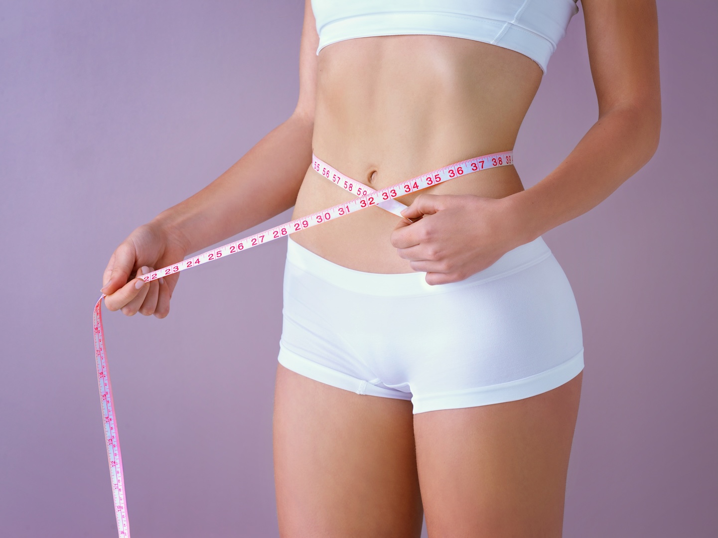 person with tape measure around midriff
