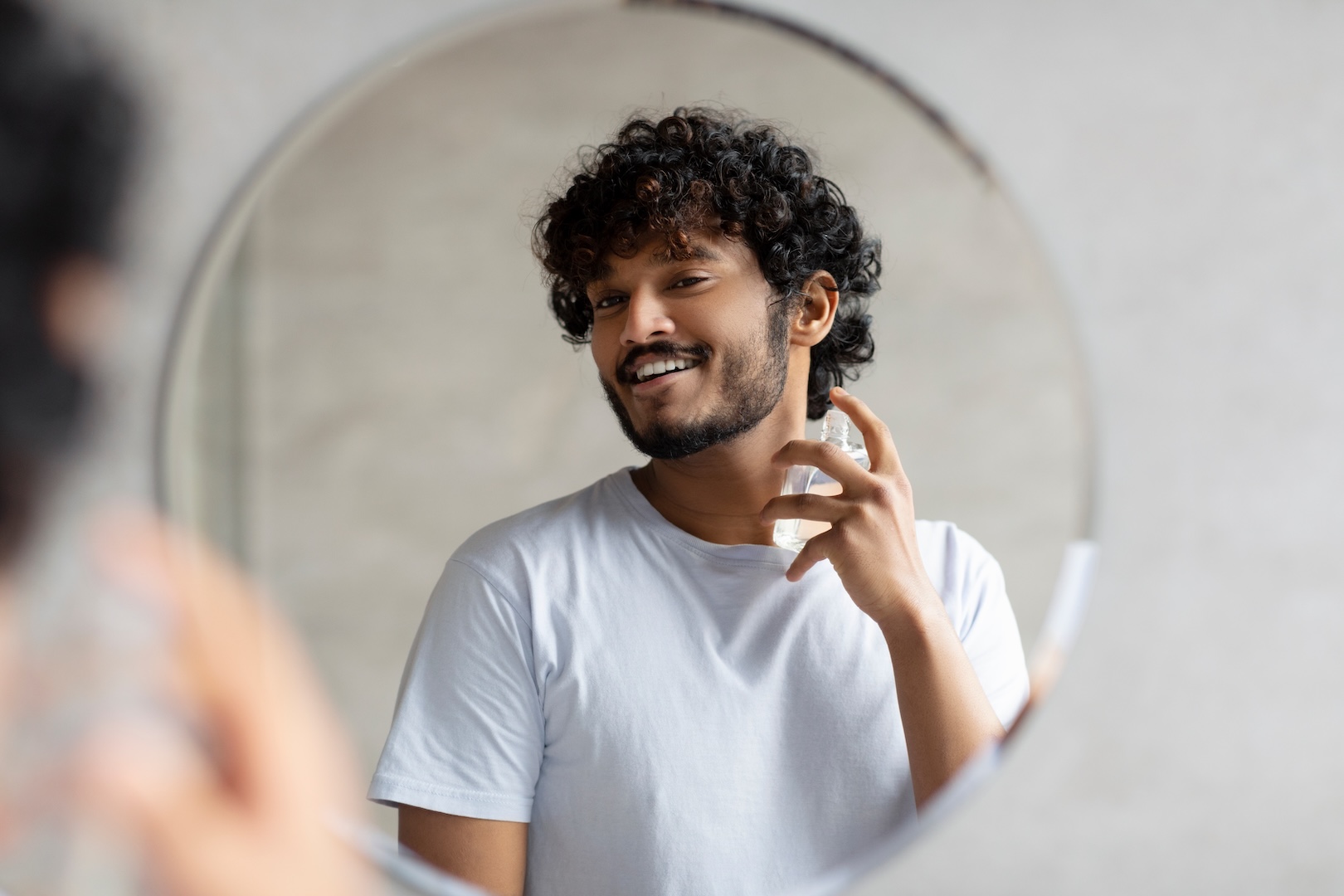 man with curly hair looking in mirror