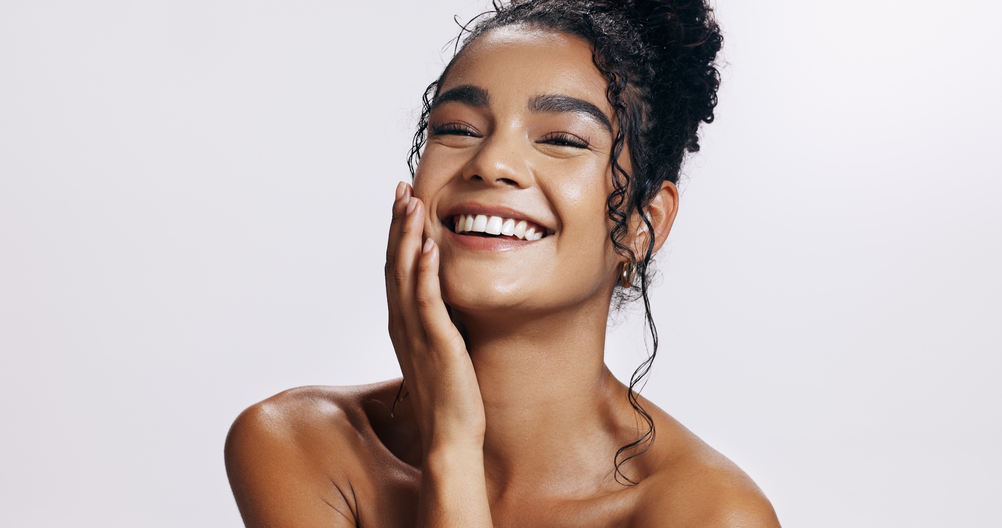young woman touching her cheek and smiling