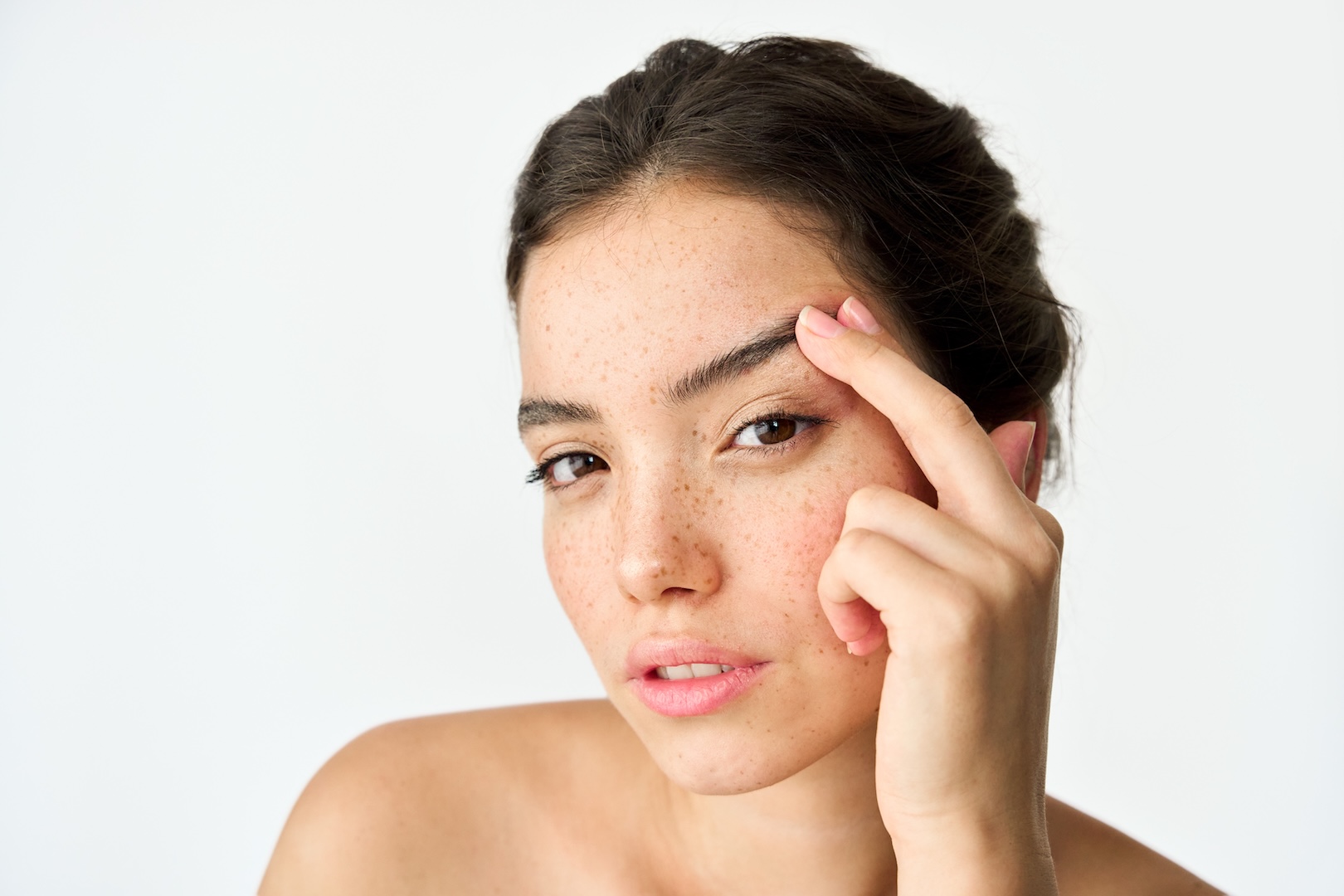 woman lifting eyebrow with finger