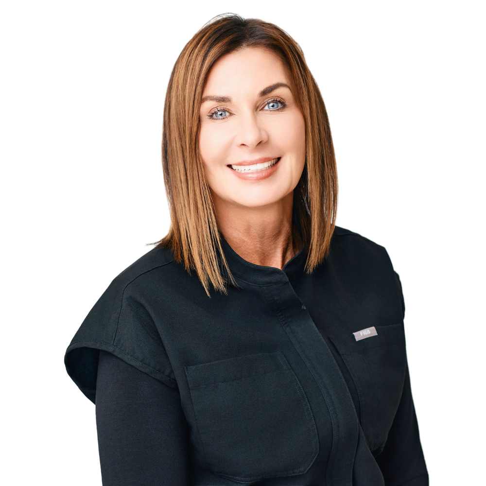 Smiling woman with straight shoulder-length brown hair wearing a black scrub top.