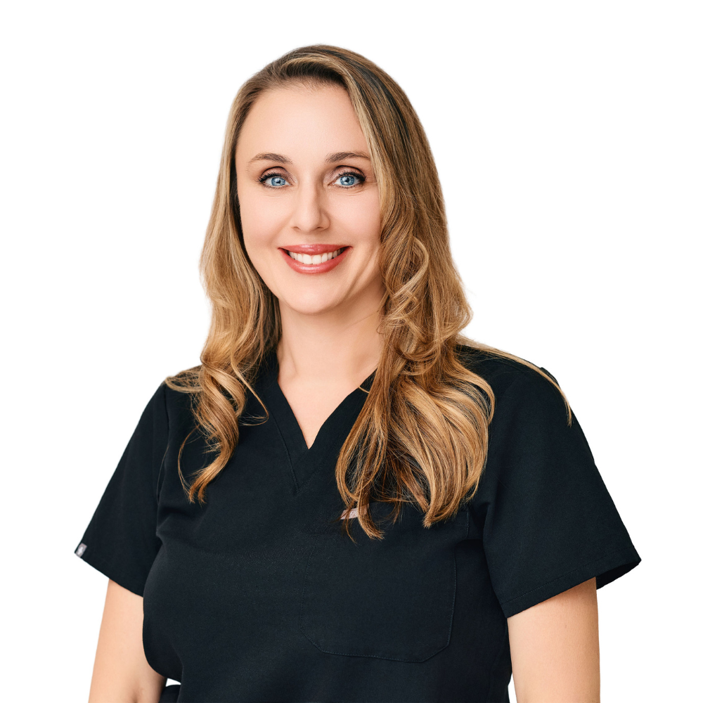 Smiling woman with long blonde hair wearing a black medical scrub top.