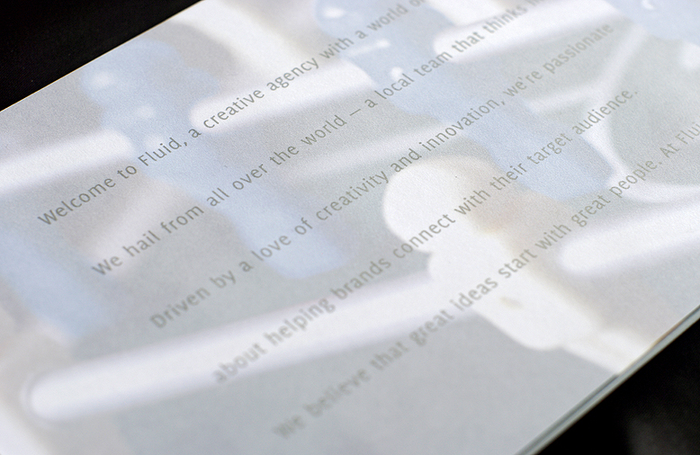 An interior spread of a company marketing brochure with the mission statement printed in silver ink on translucent paper.