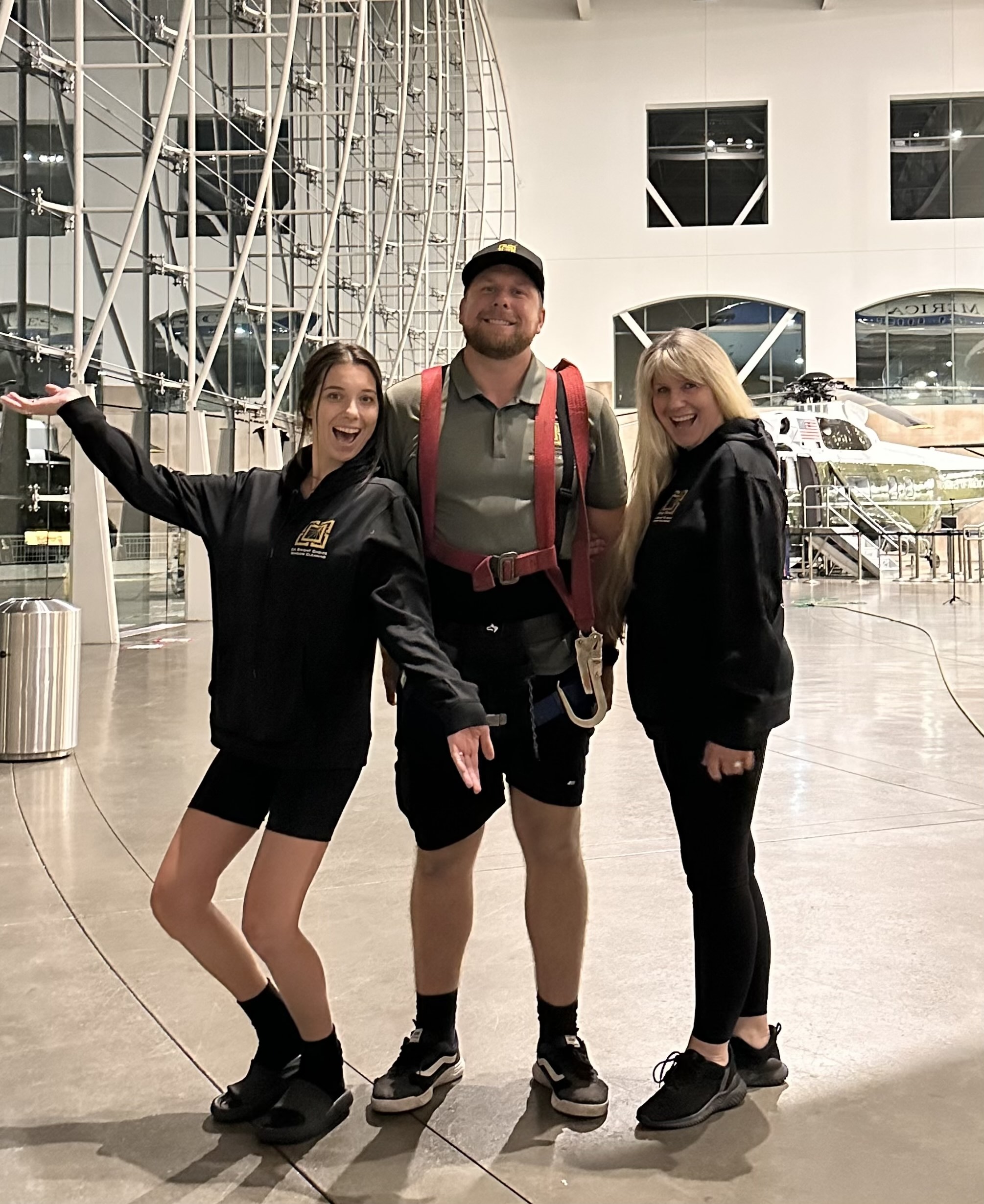 Guy with his mom and sister working in a four story aircraft hanger