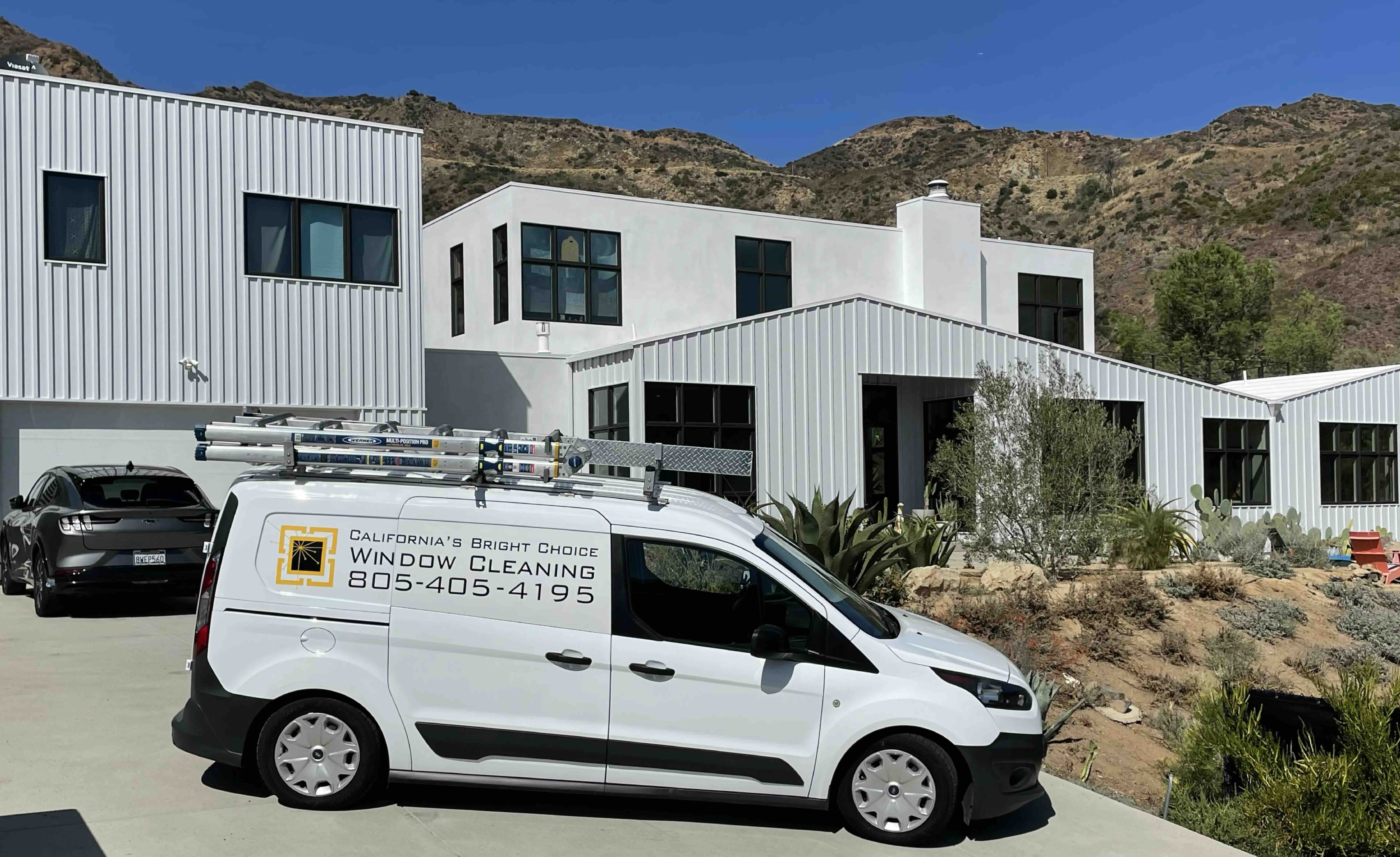 Residential window cleaning featuring the company van and the Santa Monica mountain range