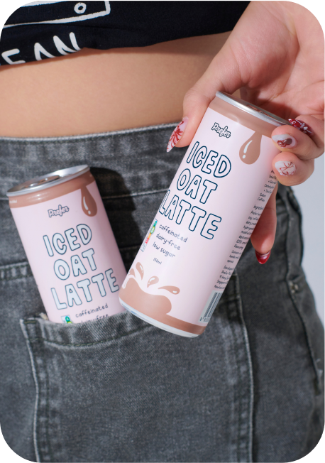 Person holding a can of iced oat latte with another can in the back pocket of their gray jeans.