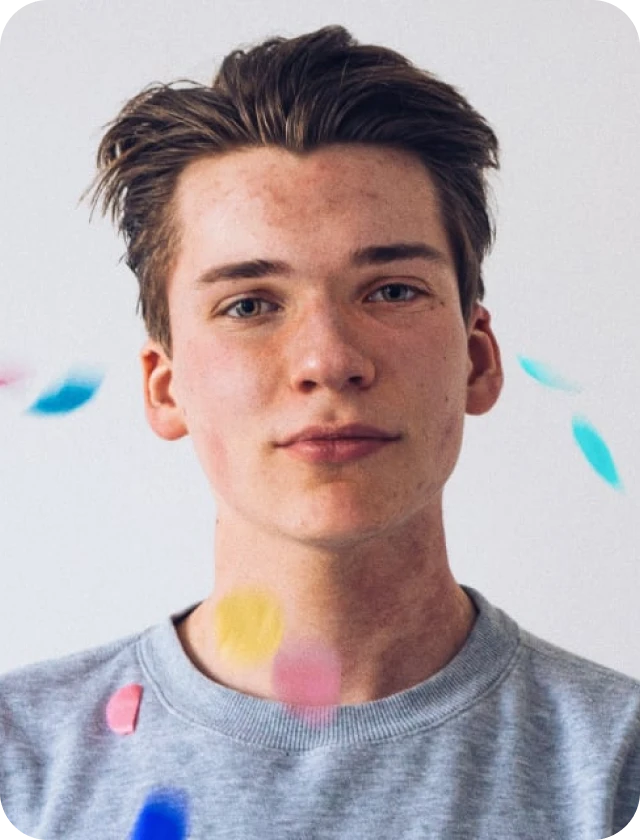 A young man with a frizzbe around his neck.