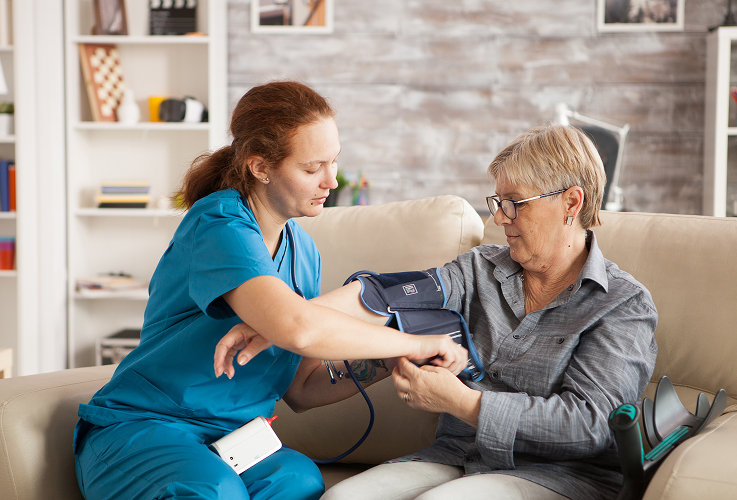 A nurse helping a patient check her blood pressure.