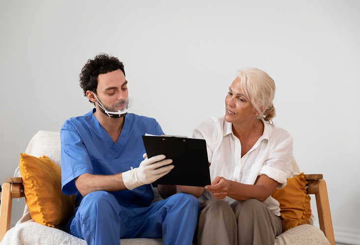 A home health care specialist assisting the elderly in speech  therapy.