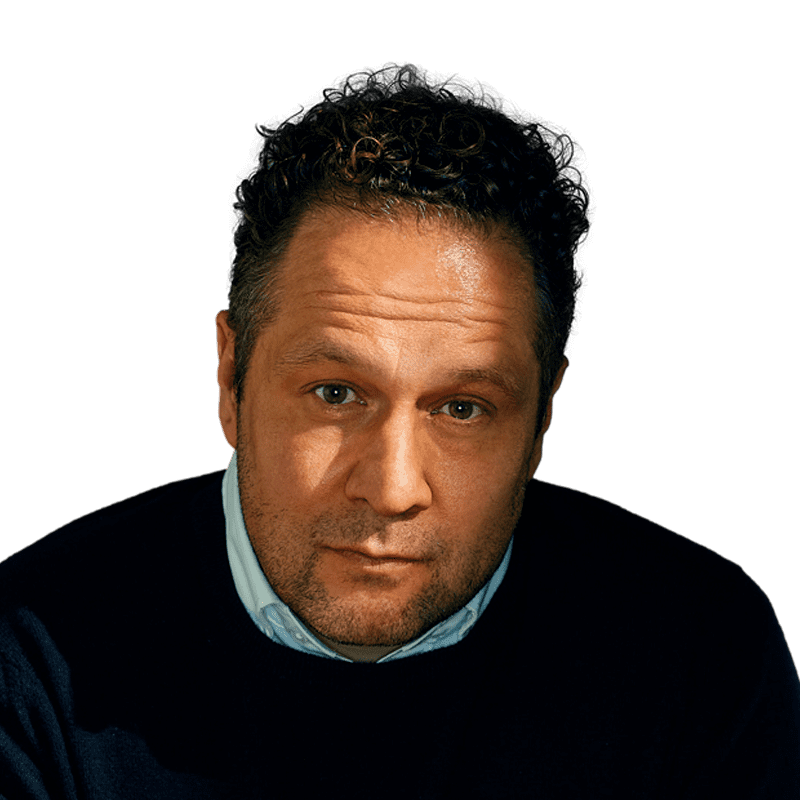 Headshot of a middle-aged man with curly dark hair and stubble, wearing a black sweater over a light blue collared shirt.
