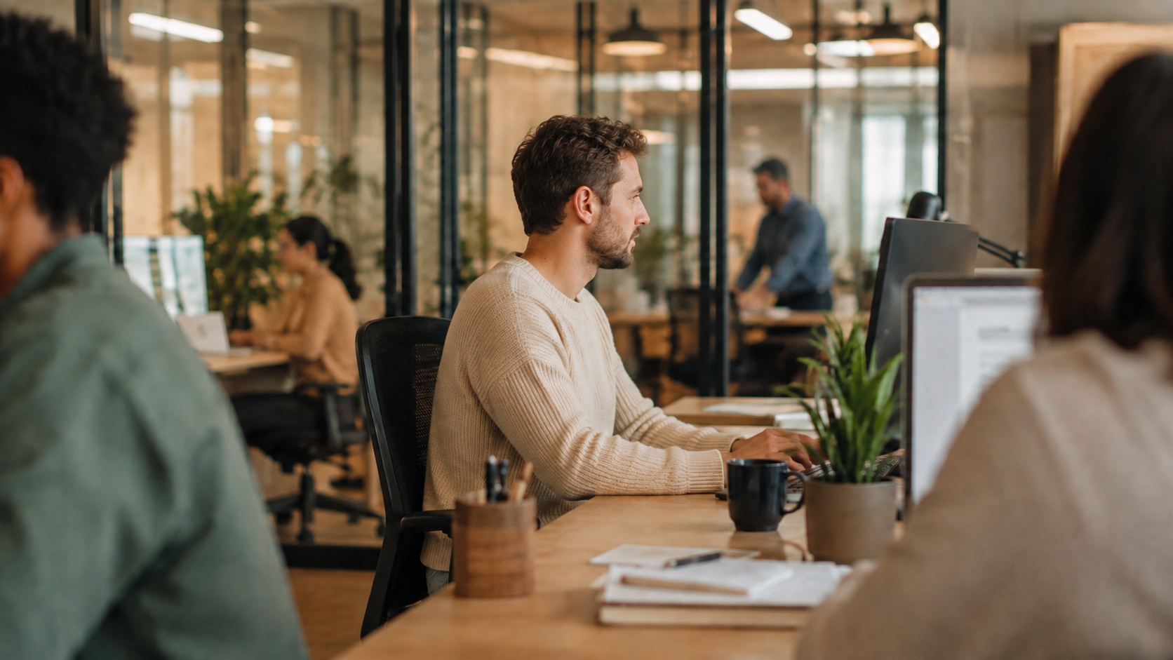A team member working on a laptop in a bright office.