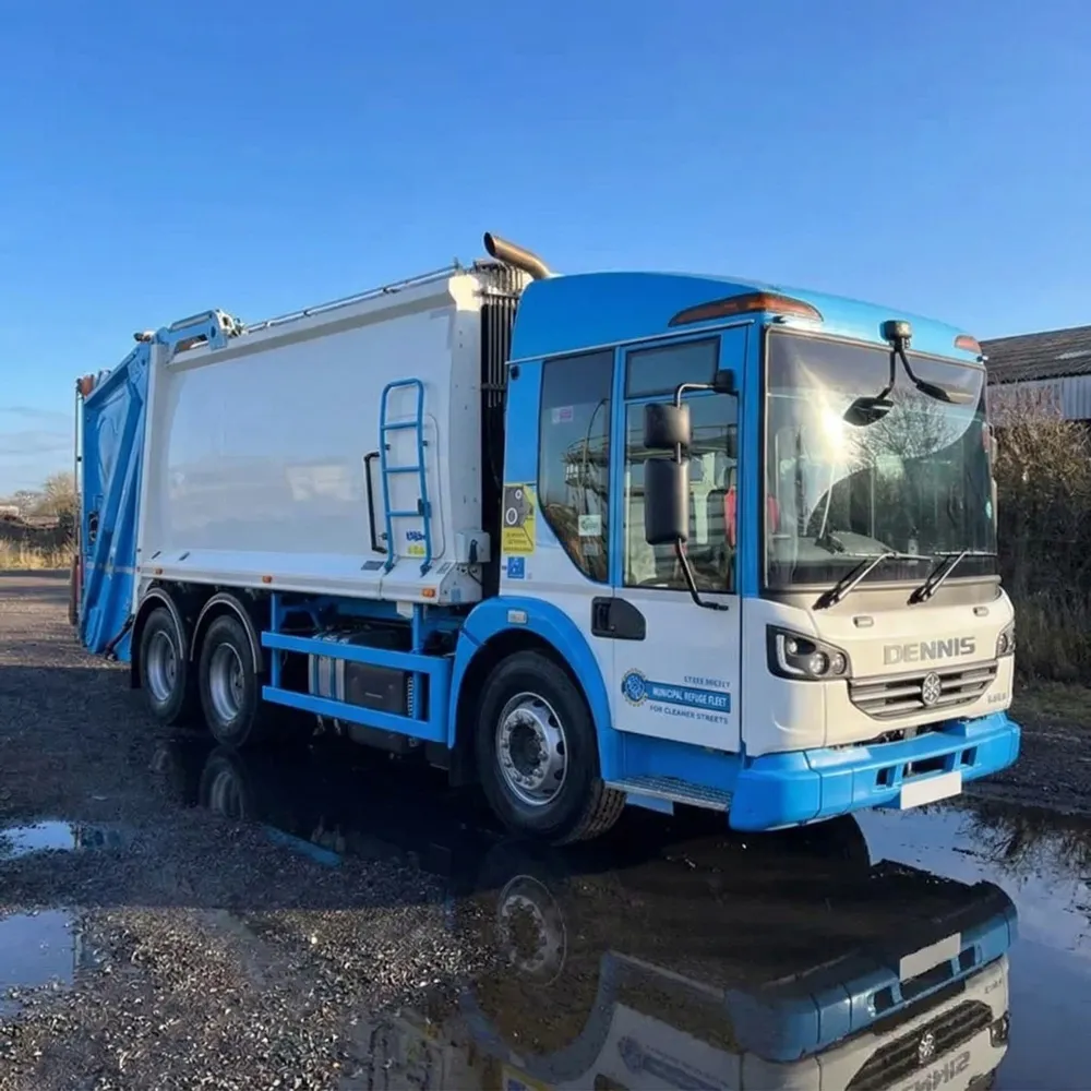 White DAF refuse truck parked on wet concrete with a blue industrial building in the background.
