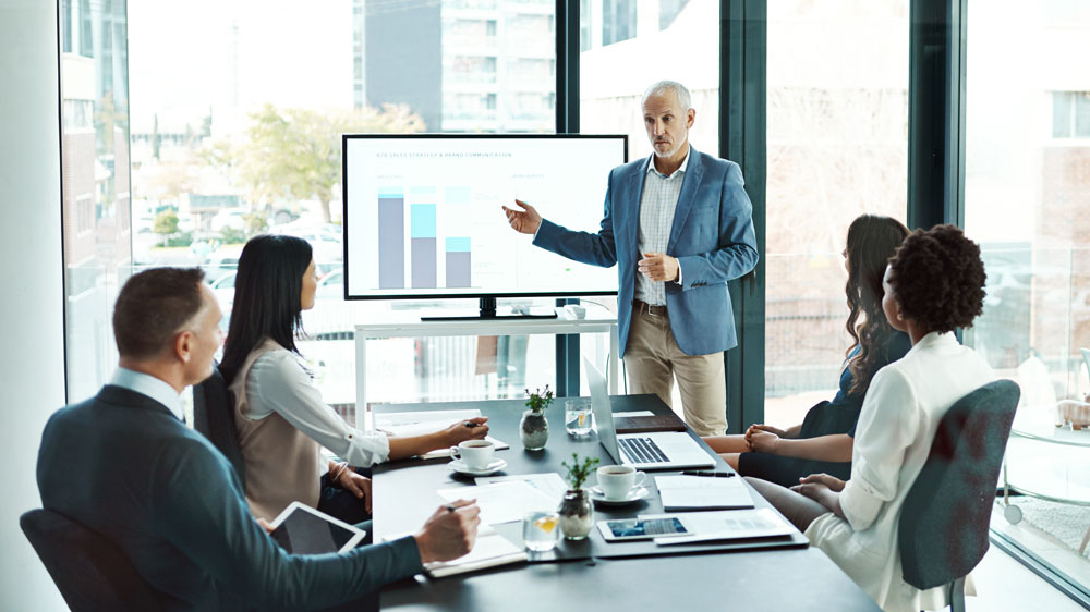 Man presenting chart to coworkers.