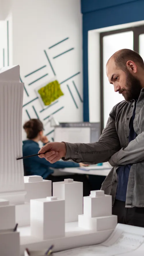 3D architectural model of a modern multi-level building with curved design and large glass windows on blueprints.