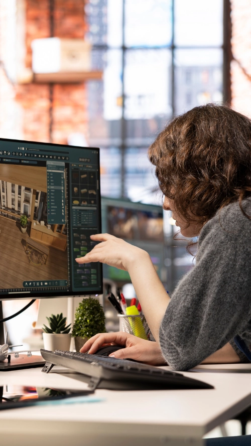 Person holding a tablet displaying programming code in a dimly lit office environment.