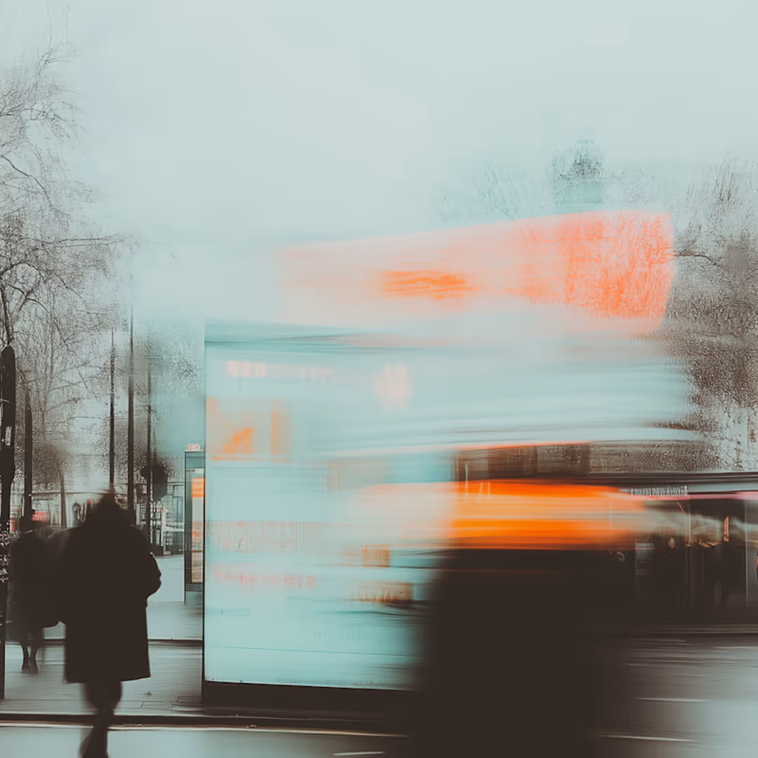 Blurry motion of people walking past a brightly lit urban billboard at dusk.