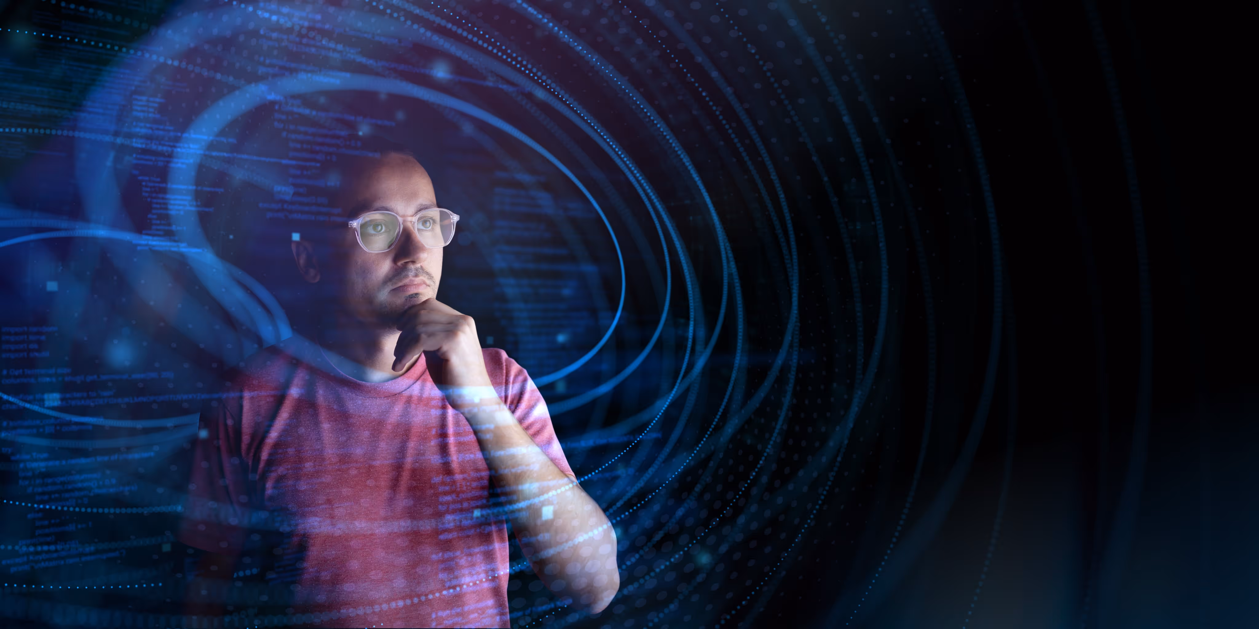 Man in glasses and red shirt thoughtfully looking at holographic blue code and digital swirls on black background.