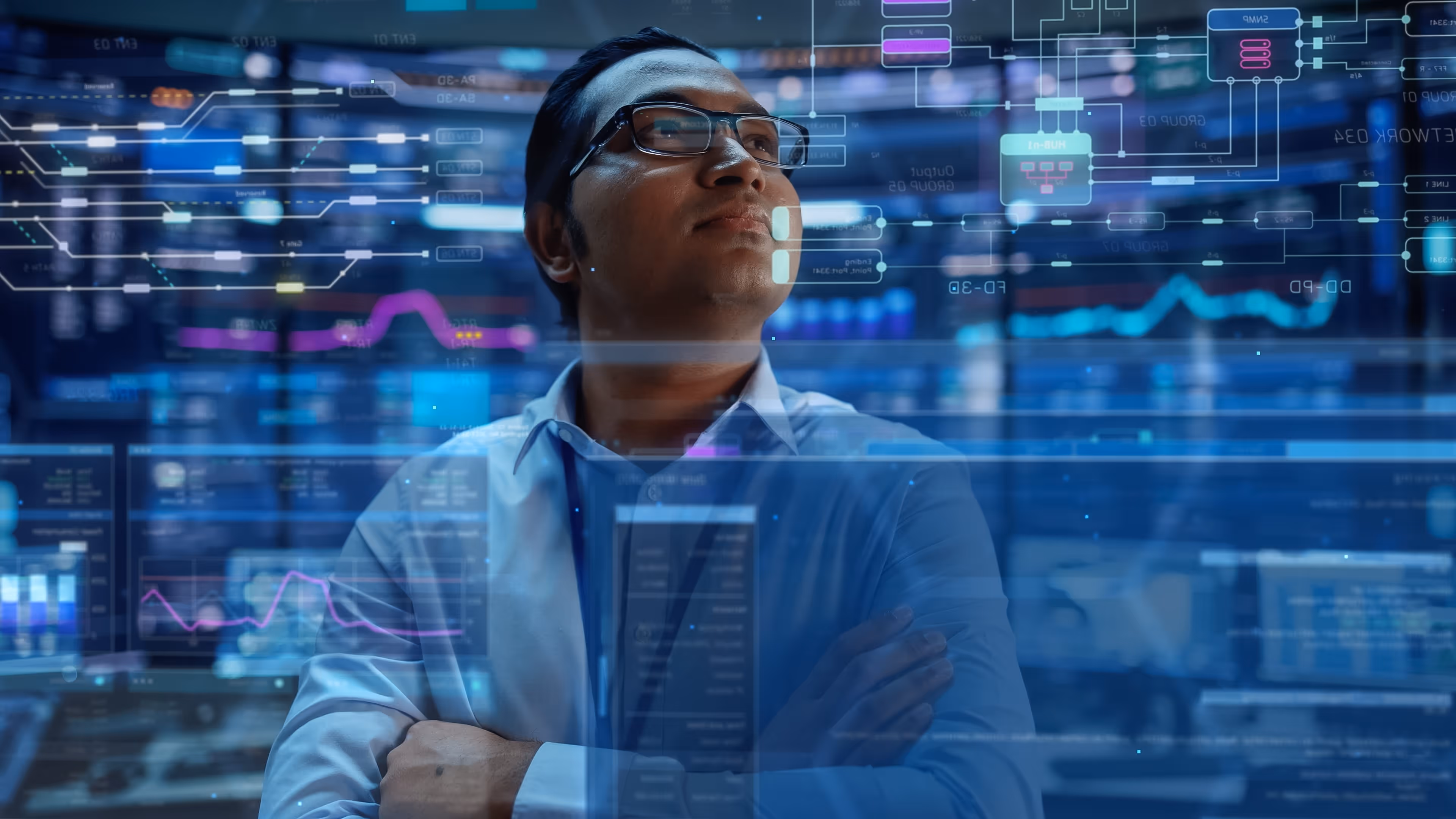 Man in glasses with arms crossed looking at transparent futuristic data and graphs displays.