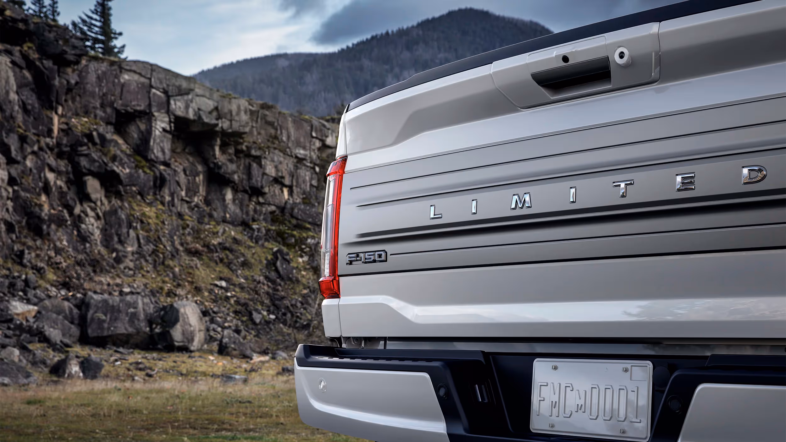 Close-up of Ford F-150 tailgate and “Limited” badging against a rocky landscape backdrop.