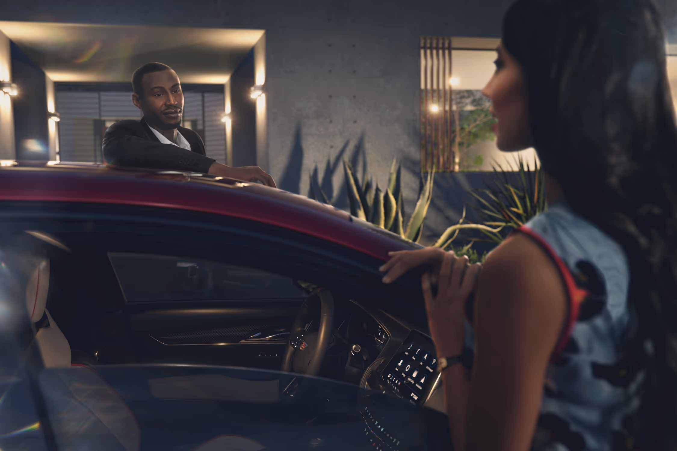 Woman speaking to man seated inside Cadillac CT5, both lit by evening light with luxury home behind.