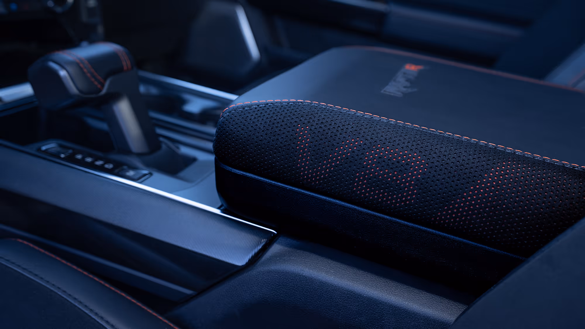 Close-up of Ford Raptor R center armrest with textured material and red stitching
