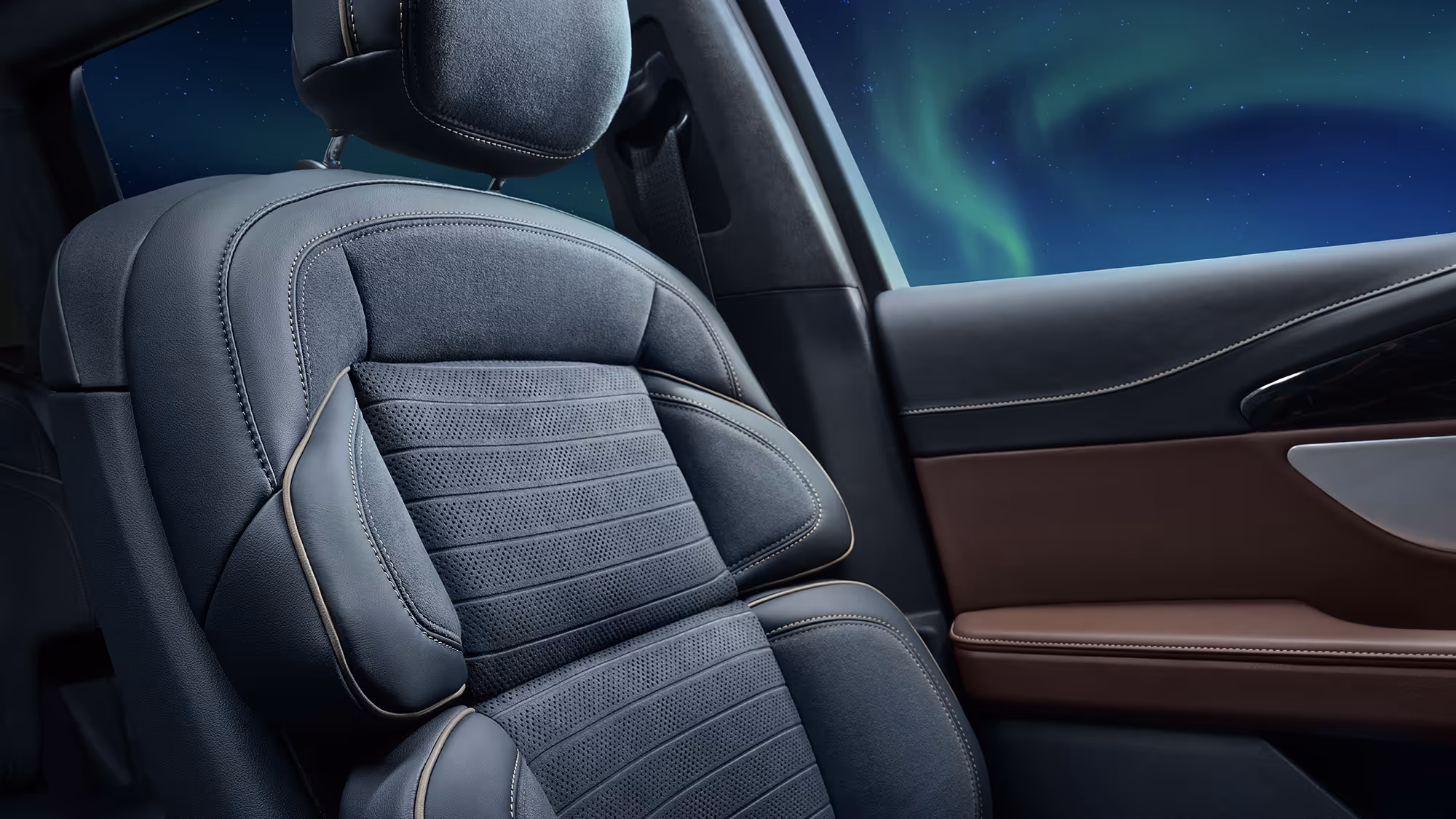 Close-up of premium leather front seat with detailed stitching inside a luxury vehicle, aurora borealis visible through the window