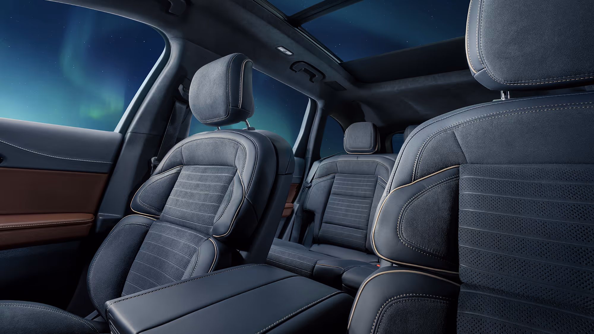 Rear passenger view of luxury vehicle interior with panoramic glass roof and aurora borealis illuminating the cabin
