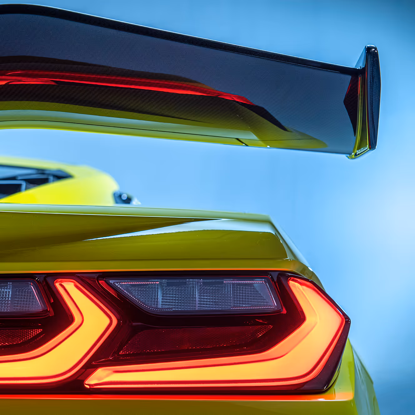 Detail of rear wing and taillight with illuminated LED signature, emphasizing aerodynamic design and sharp styling.