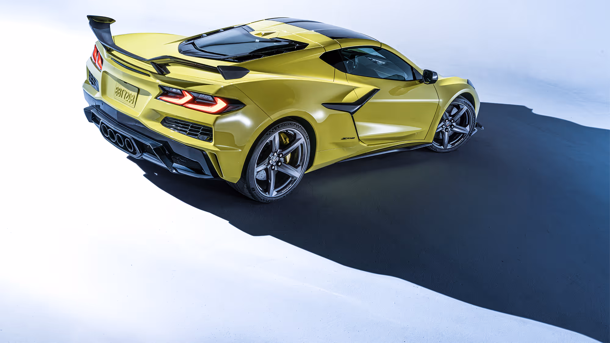 Wide rear three-quarter view of the car on a clean studio floor, with strong shadow adding depth and presence.
