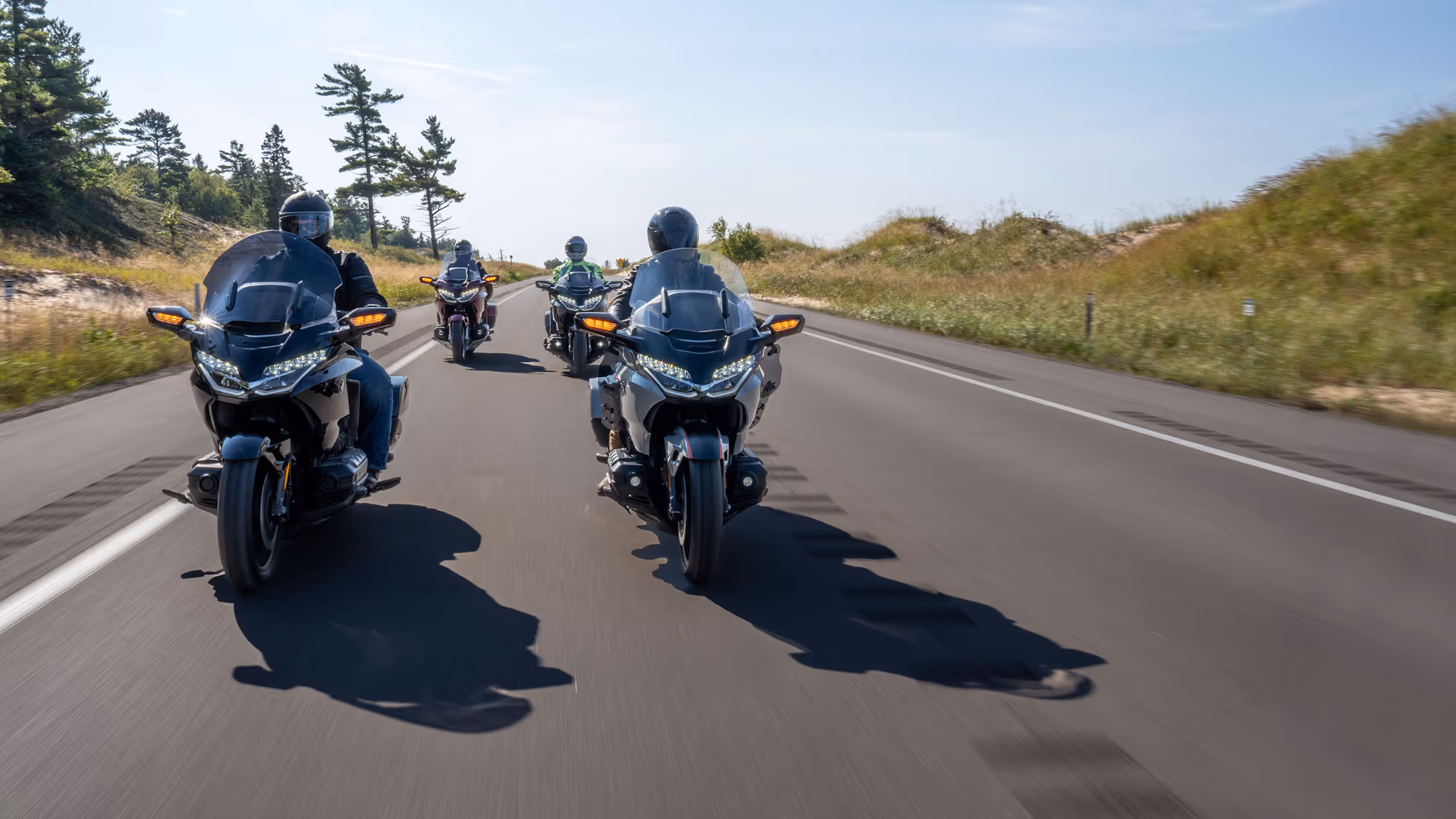 Rear view of a Gold Wing group riding in formation on a sunny road