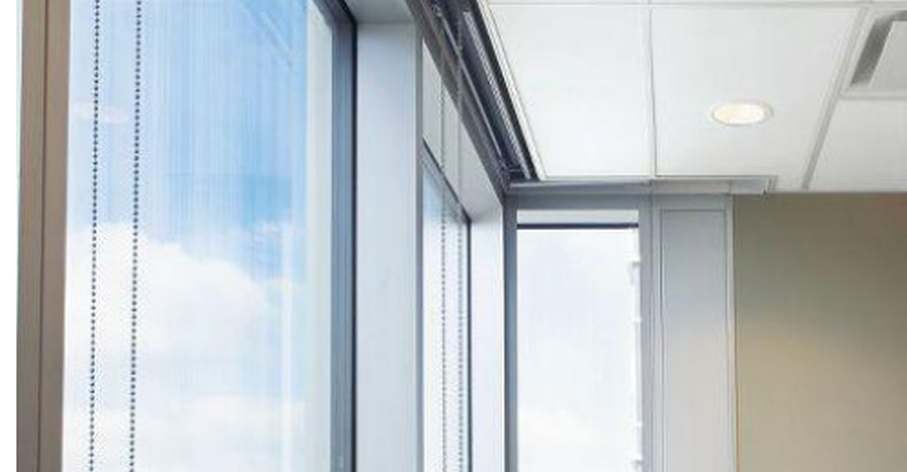 Roller shades with a clean fascia installed on floor-to-ceiling windows