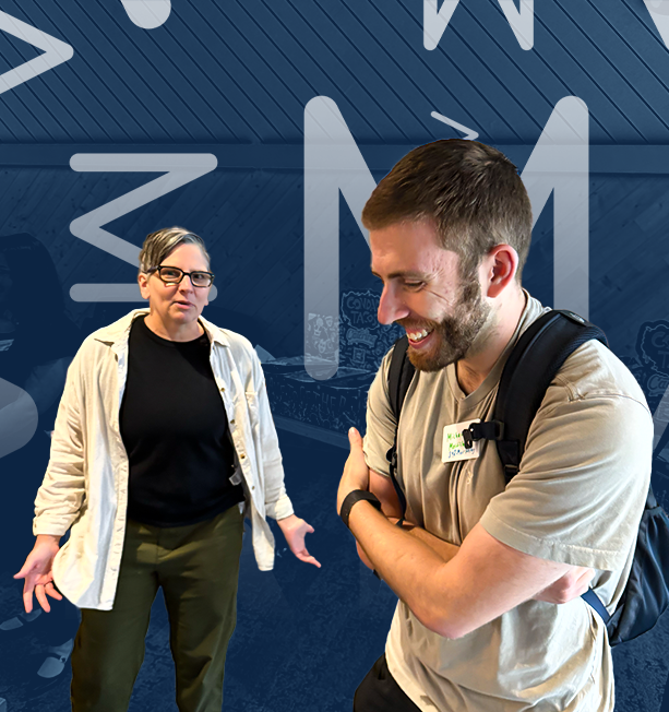 Two people smiling and talking, one with a backpack and the other wearing glasses.