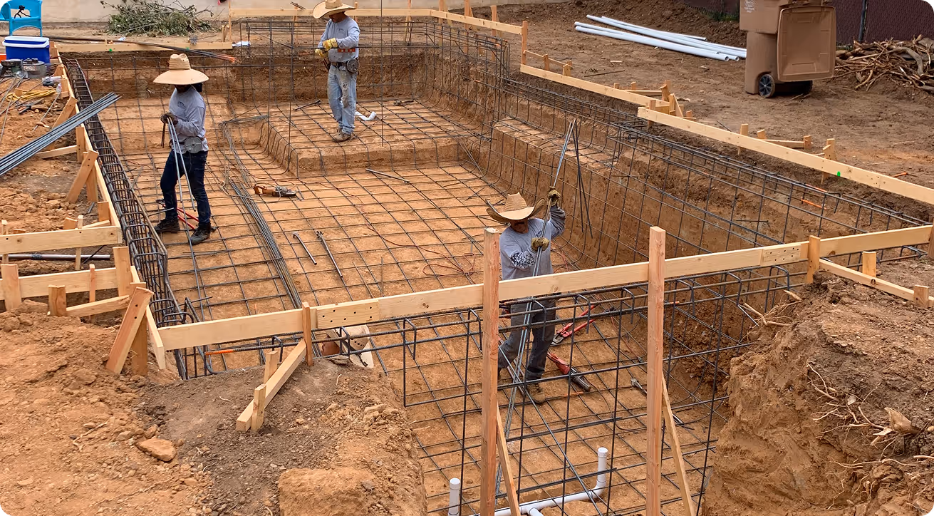Construction workers preparing rebar foundation for concrete structure
