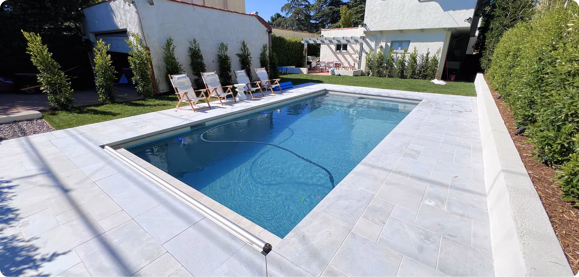 Backyard swimming pool with lounge chairs and landscaped garden