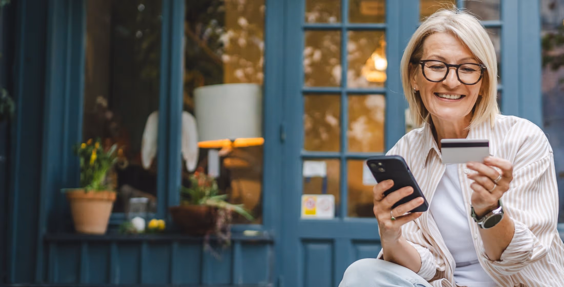 Older woman shopping with credit card in hand shopping on her phone